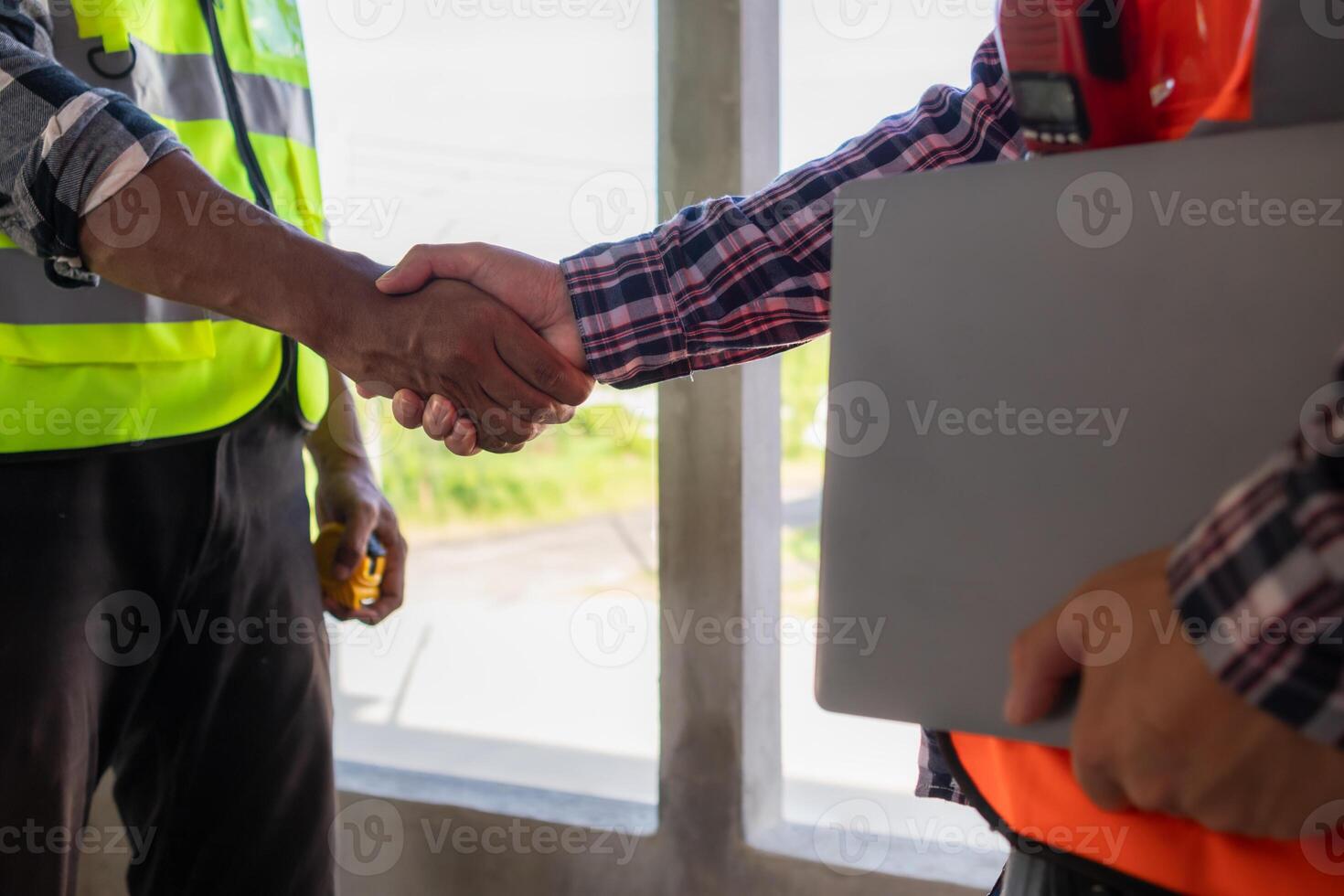 Behind the scenes foreman wearing reflective vest and hard hat inspects construction site to ensure construction meets engineering team's design plans and for the beauty and safety of residents. photo
