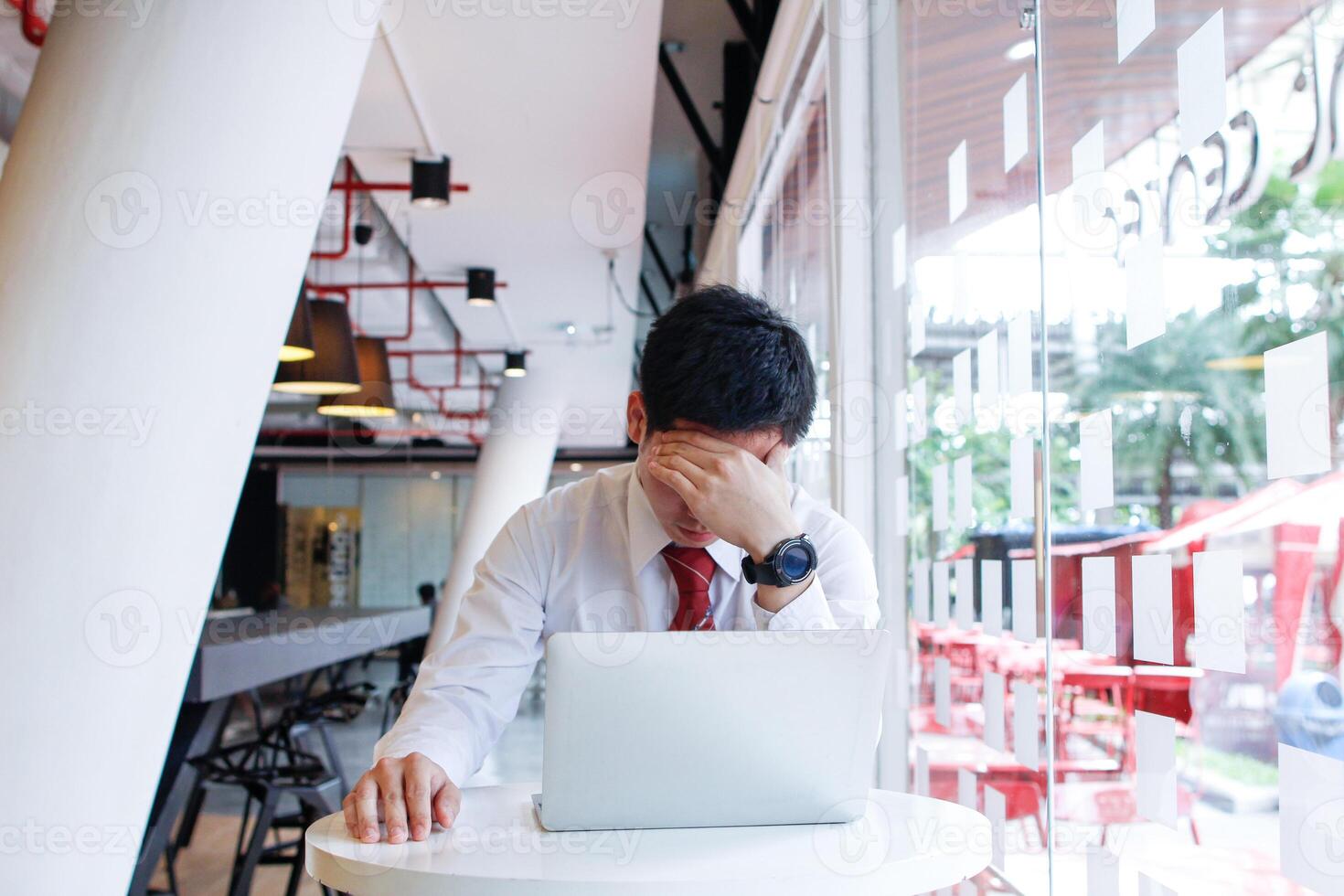 A businessman who is in a state of failure because his investments do not meet his goals lead to stress and headaches. The concept of a headache due to the wrong businessman's investment. photo