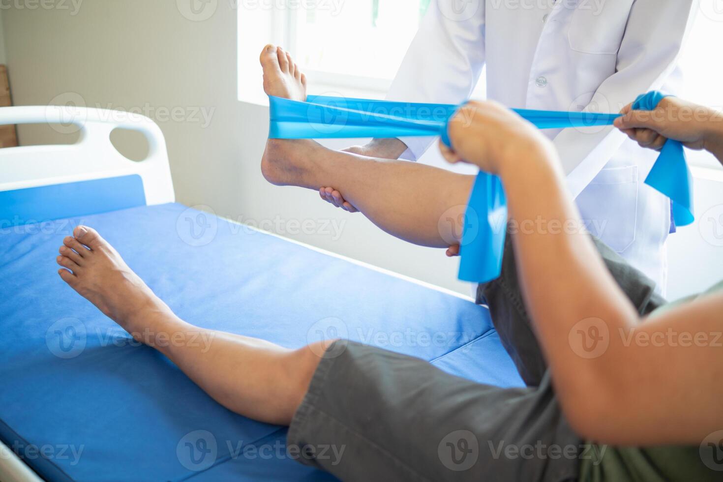 female doctor using elastic bands help patient regain muscle movement after recuperating from muscle injury and wants rehabilitate her be able use her normal daily life by practicing physical therapy photo