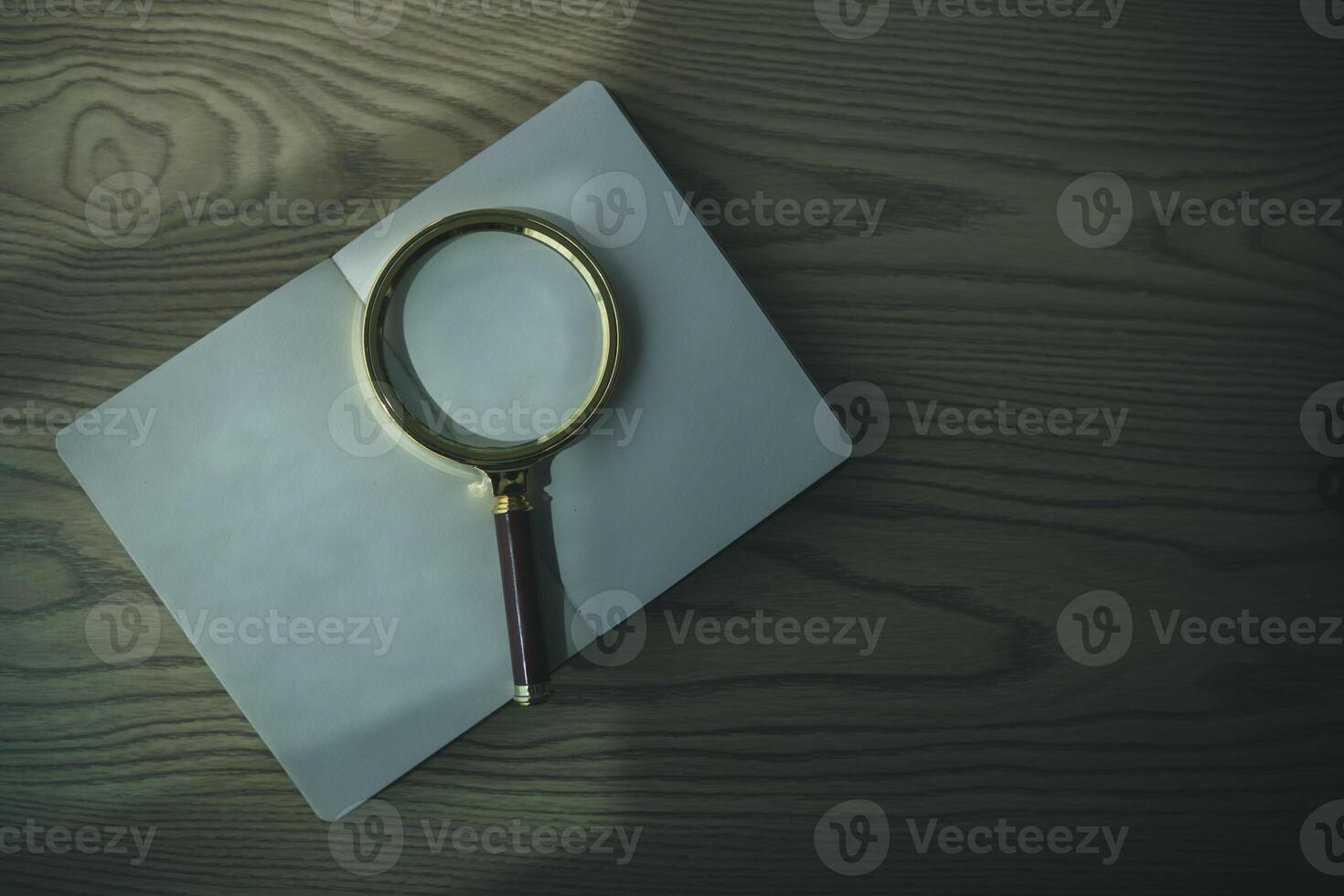 A Bible and a magnifying glass are placed on a wooden table after praying to God Christian religious ritual and belief in the teachings of God. Ideas for praying to God with teachings from the Bible photo
