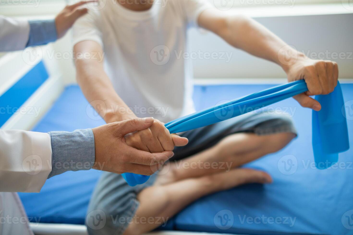female doctor using elastic bands help patient regain muscle movement after recuperating from muscle injury and wants rehabilitate her be able use her normal daily life by practicing physical therapy photo