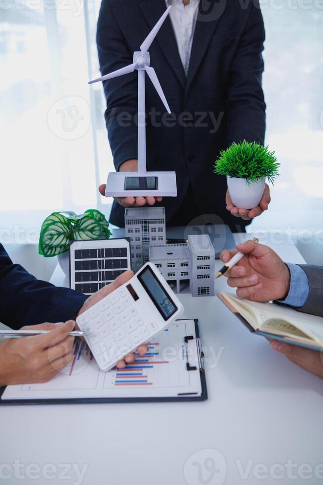 Businessmen, investors and electrical engineers discuss clean energy residential projects help reduce global warming and use clean energy from wind and sunlight. concept clean energy projects photo