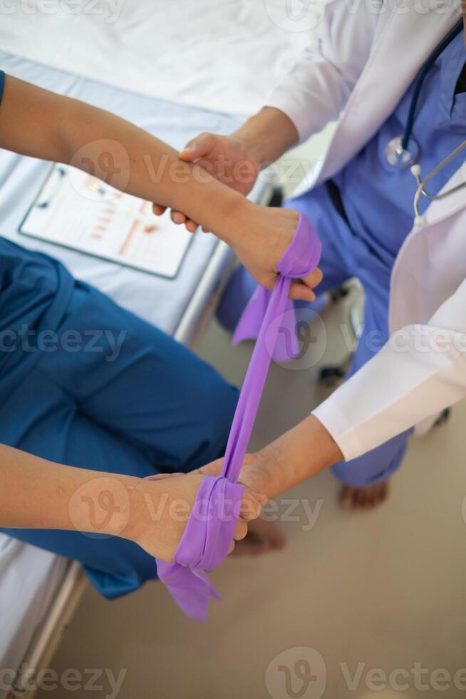 doctor is examining muscle injury and using elastic bands test injury and also help with physical therapy strengthen muscles because physical therapy will help strengthen muscles and help blood flow. photo