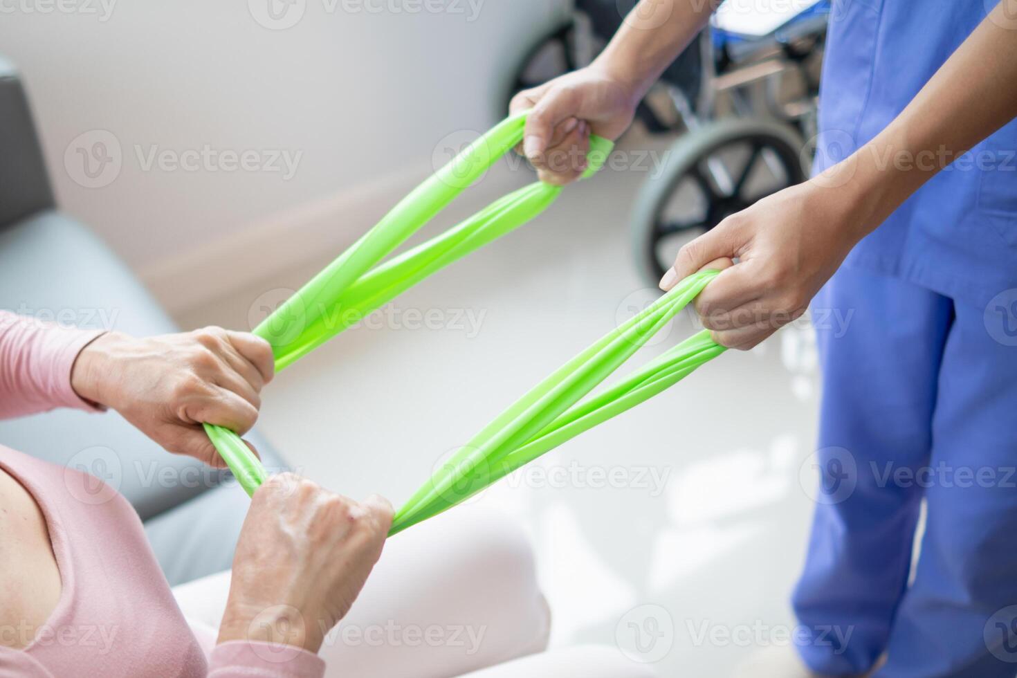 female doctor using elastic bands help patient regain muscle movement after recuperating from muscle injury and wants rehabilitate her be able use her normal daily life by practicing physical therapy photo