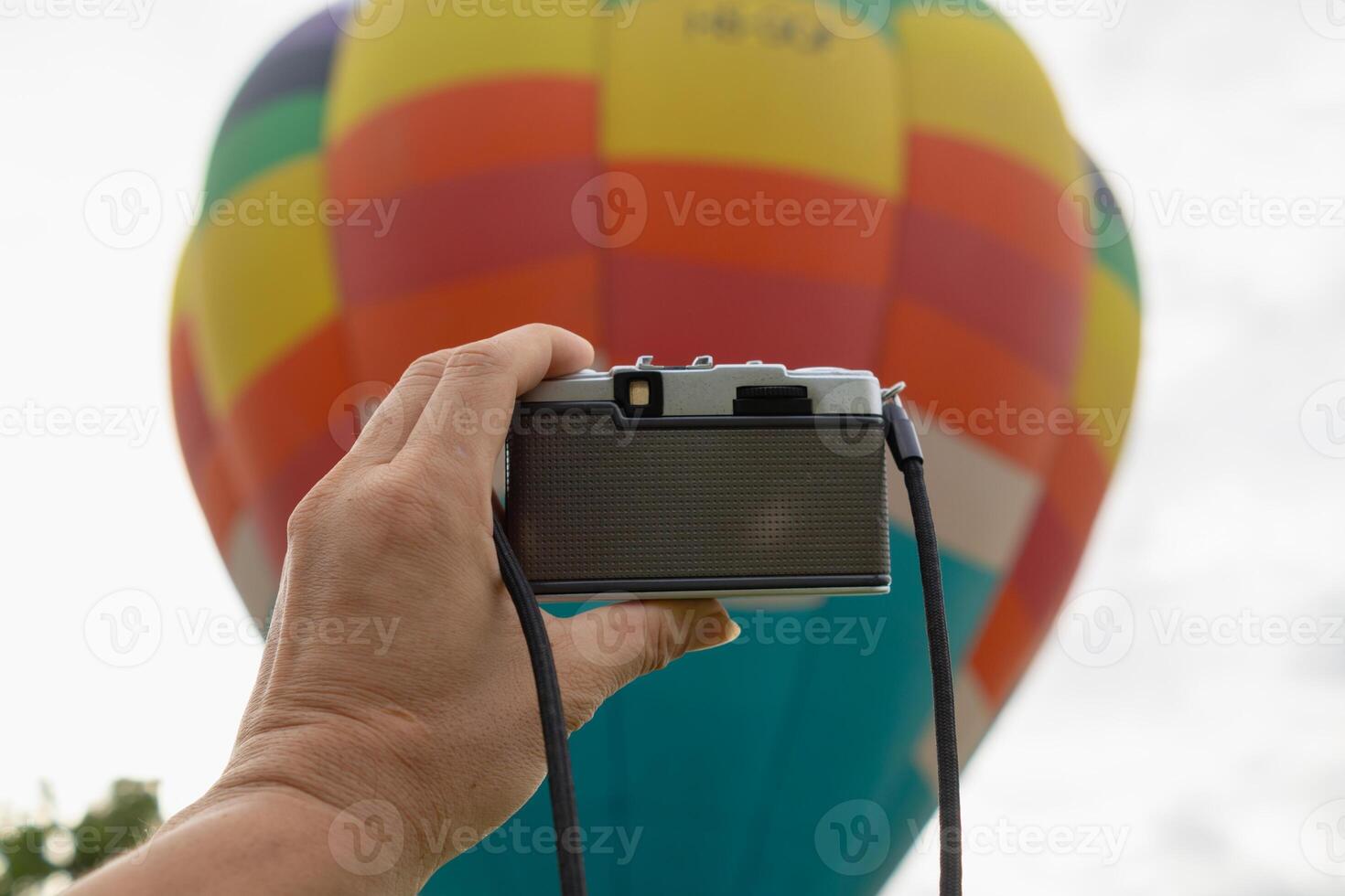 young photographer holds vintage style film camera in her hand and inspects film camera for use after film cameras have become popular with photographers today because of their unique image tones. photo