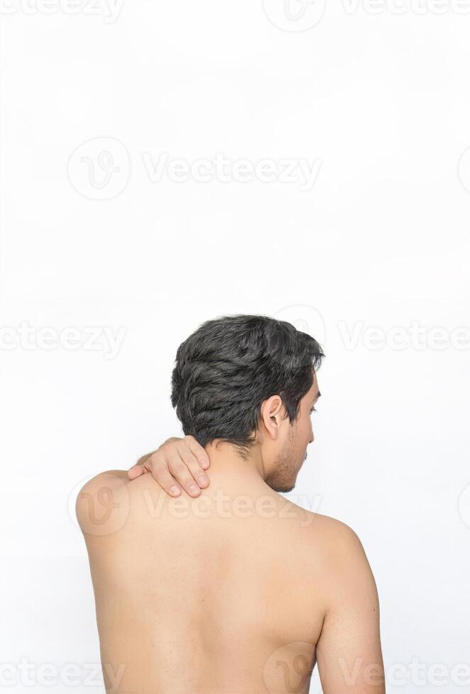 Shirtless man with neck pain showing back with white background and space for text above. photo