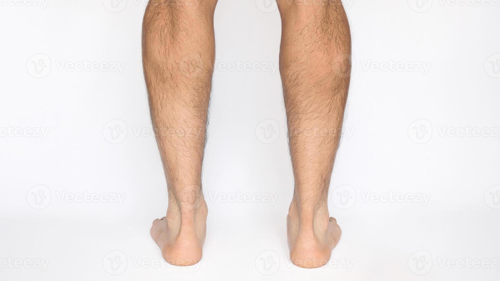 Adult male feet seen from behind observing Achilles heels and calves, with a white background photo