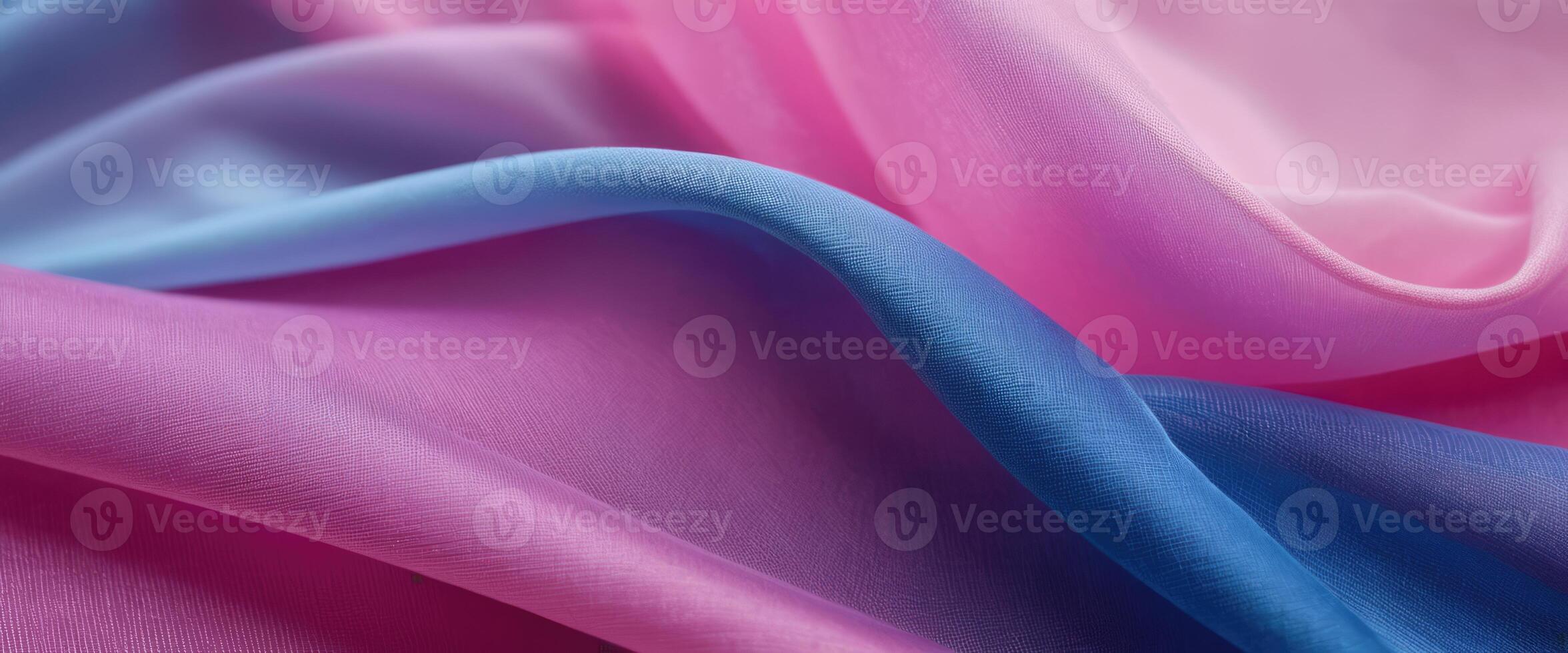 The thin pink and blue fabric sags in folds under its own weight photo
