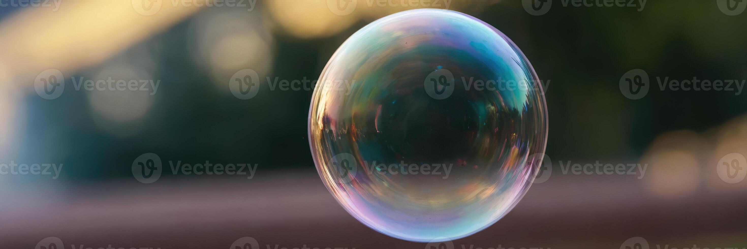 A single soap bubble flies against a blurred background. photo