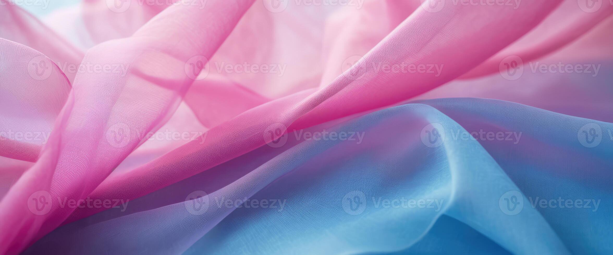 The thin pink and blue fabric sags in folds under its own weight photo