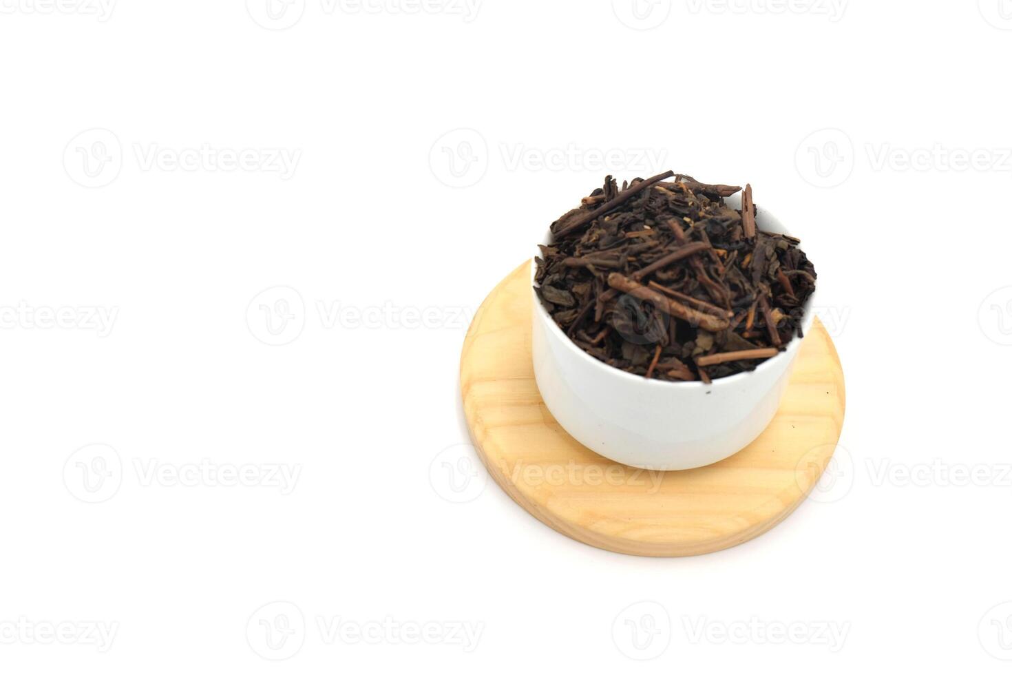 Dry black tea in round bowl isolated on white background photo