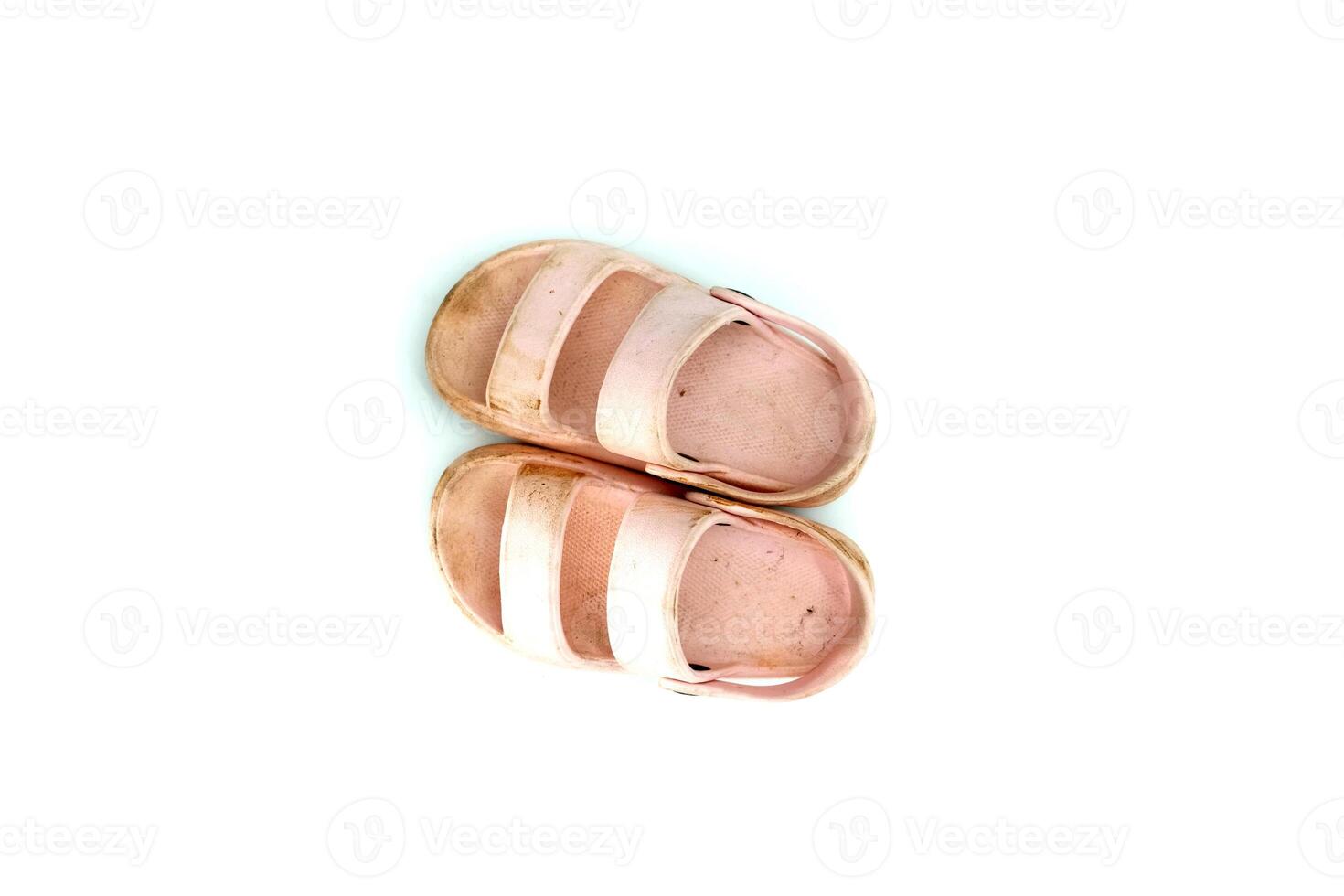 The girl's dirty pink slippers on a white background photo
