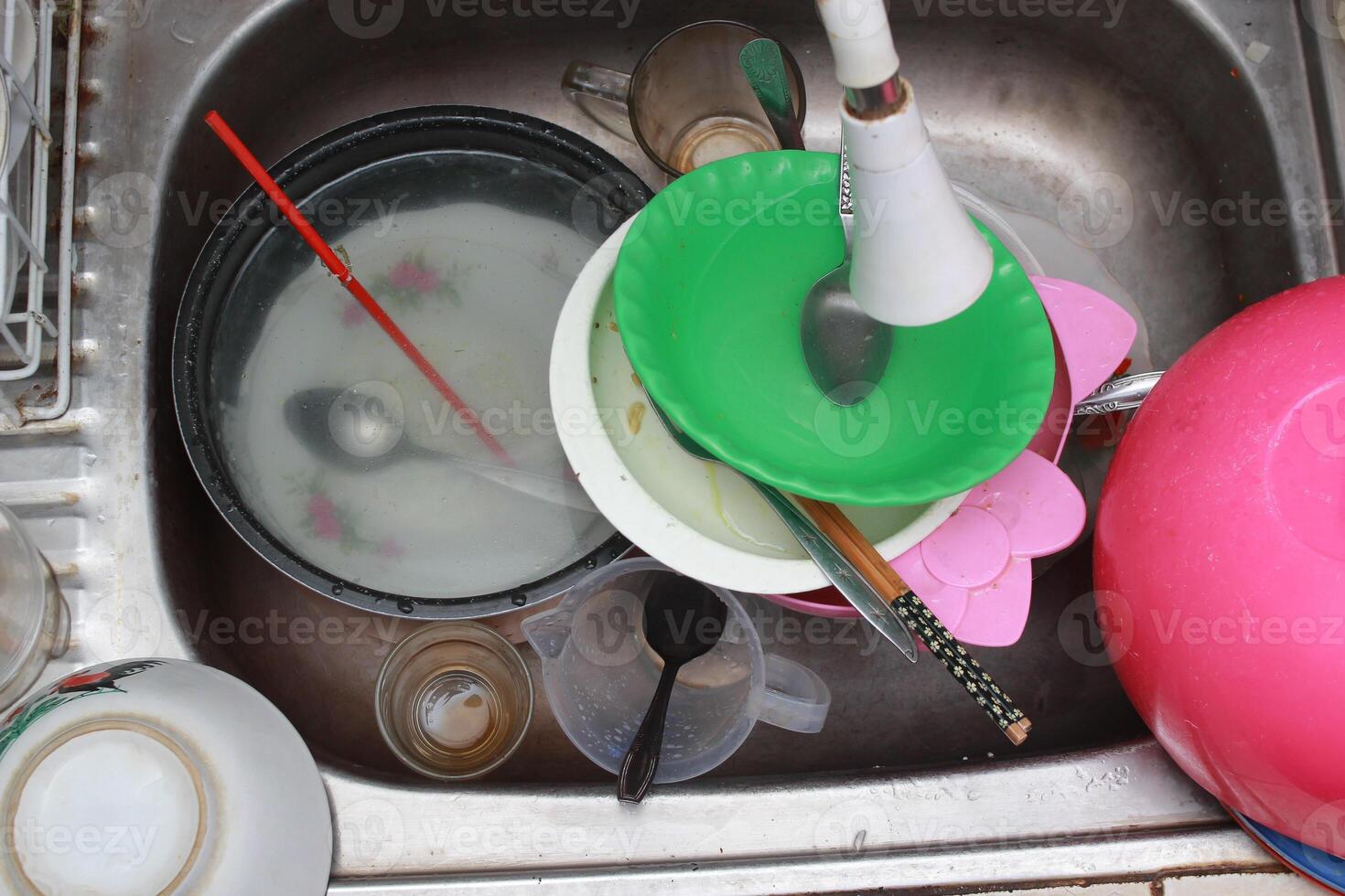 the sink is full of dirty dishes photo