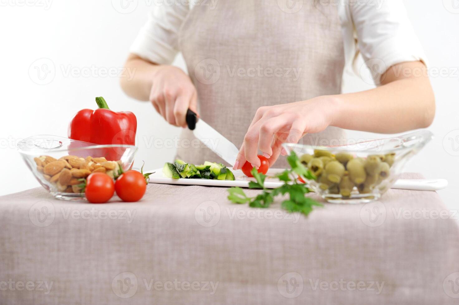 Woman eating steamed vegetable in the brown kraft paper food container on white wooden background. photo