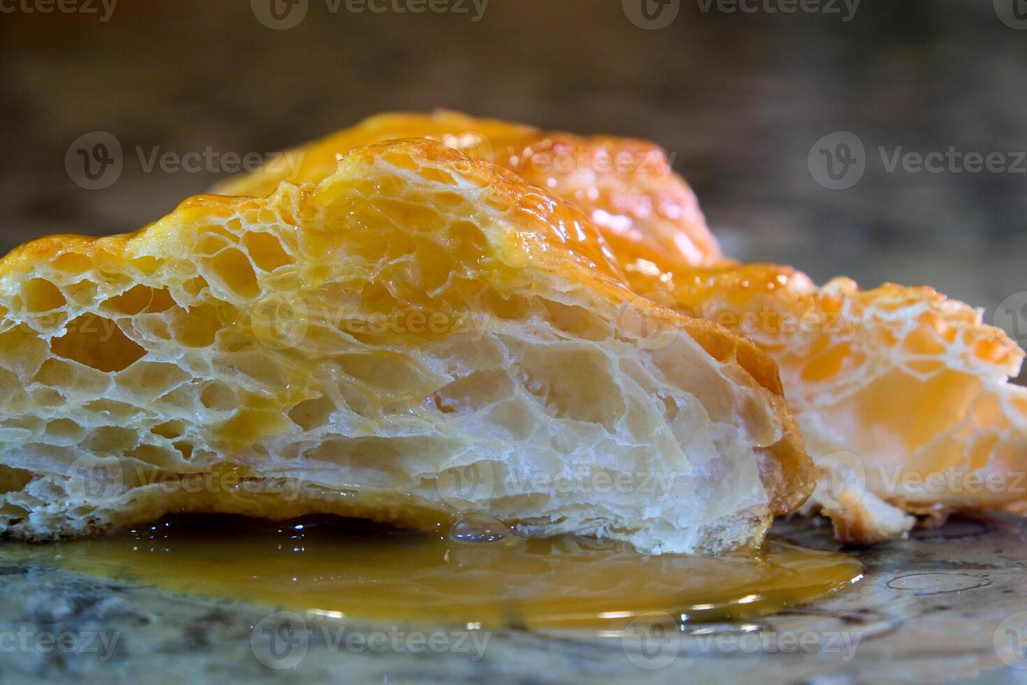 delicious appetizing cut croissant porous structure of puff pastry syrup next to two fresh strawberries on a marble table white plate close-up space for text advertising offers photo for recipe book