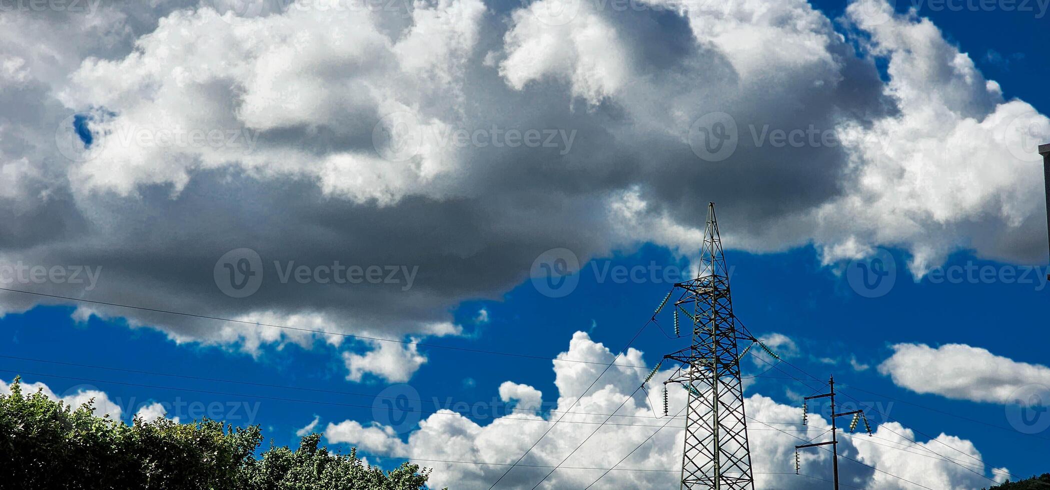 High voltage poles with cloudy skies as a backdrop in the Italian territory of Liguria in the spring of 2024 photo