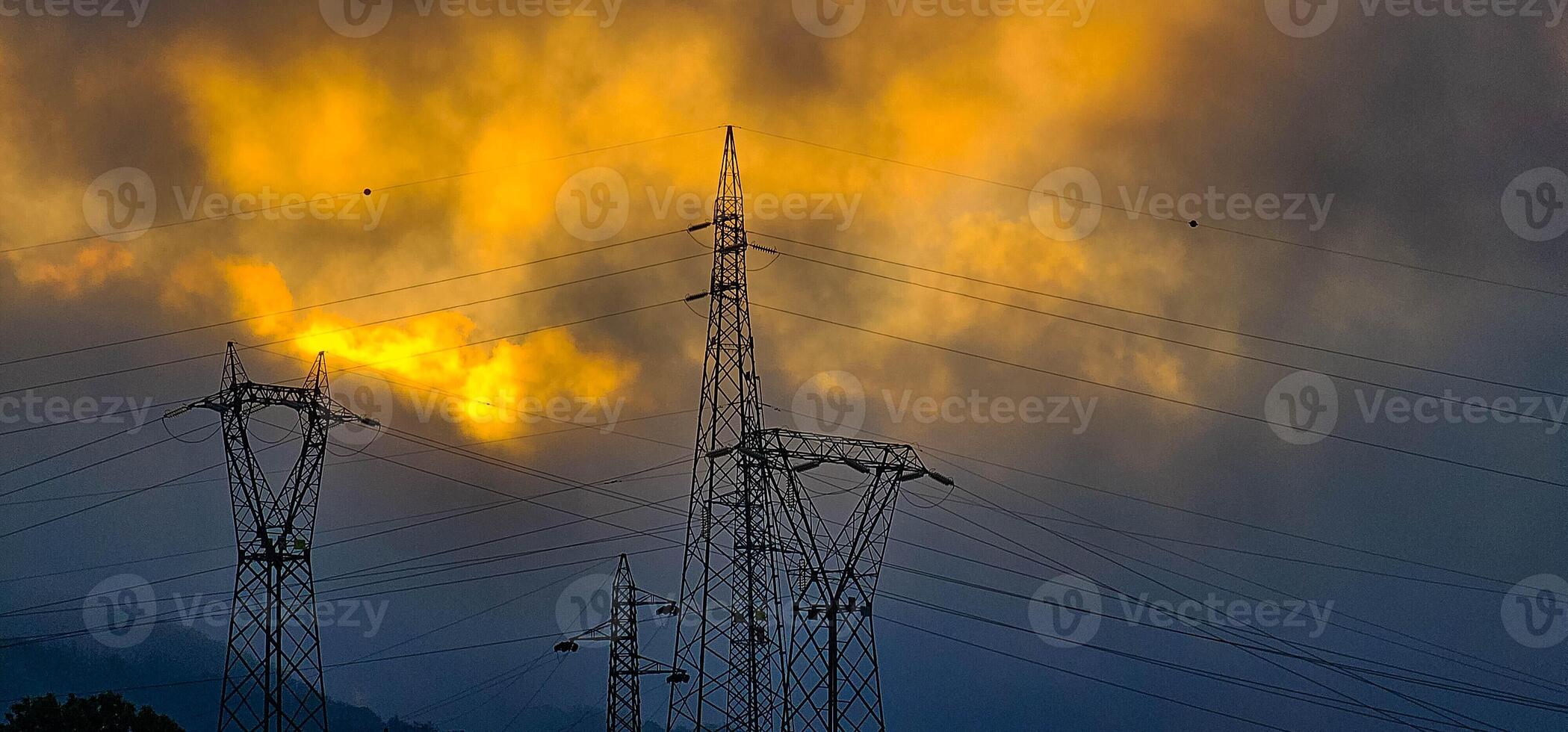 High voltage poles with cloudy skies as a backdrop in the Italian territory of Liguria in the spring of 2024 photo