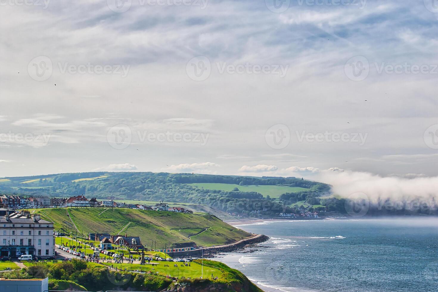 Scenic coastal view with green hills and small town in Whitby, North Yorkshire photo