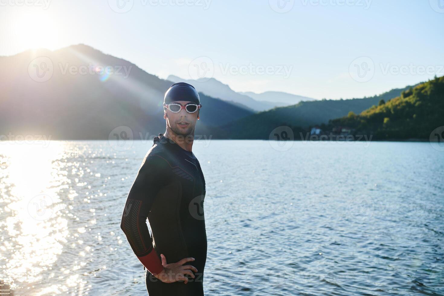 Authentic triathlon athlete getting ready for swimming training on lake photo