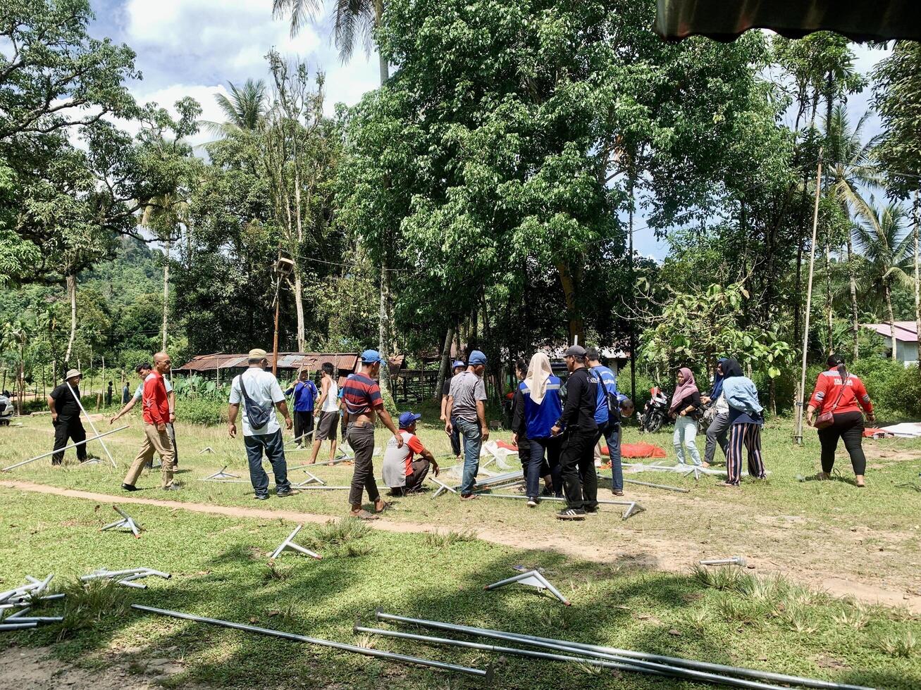 Indonesia - Sibolga 08 Mei 2024 a group of asian people are learning to set up a tent in the field photo