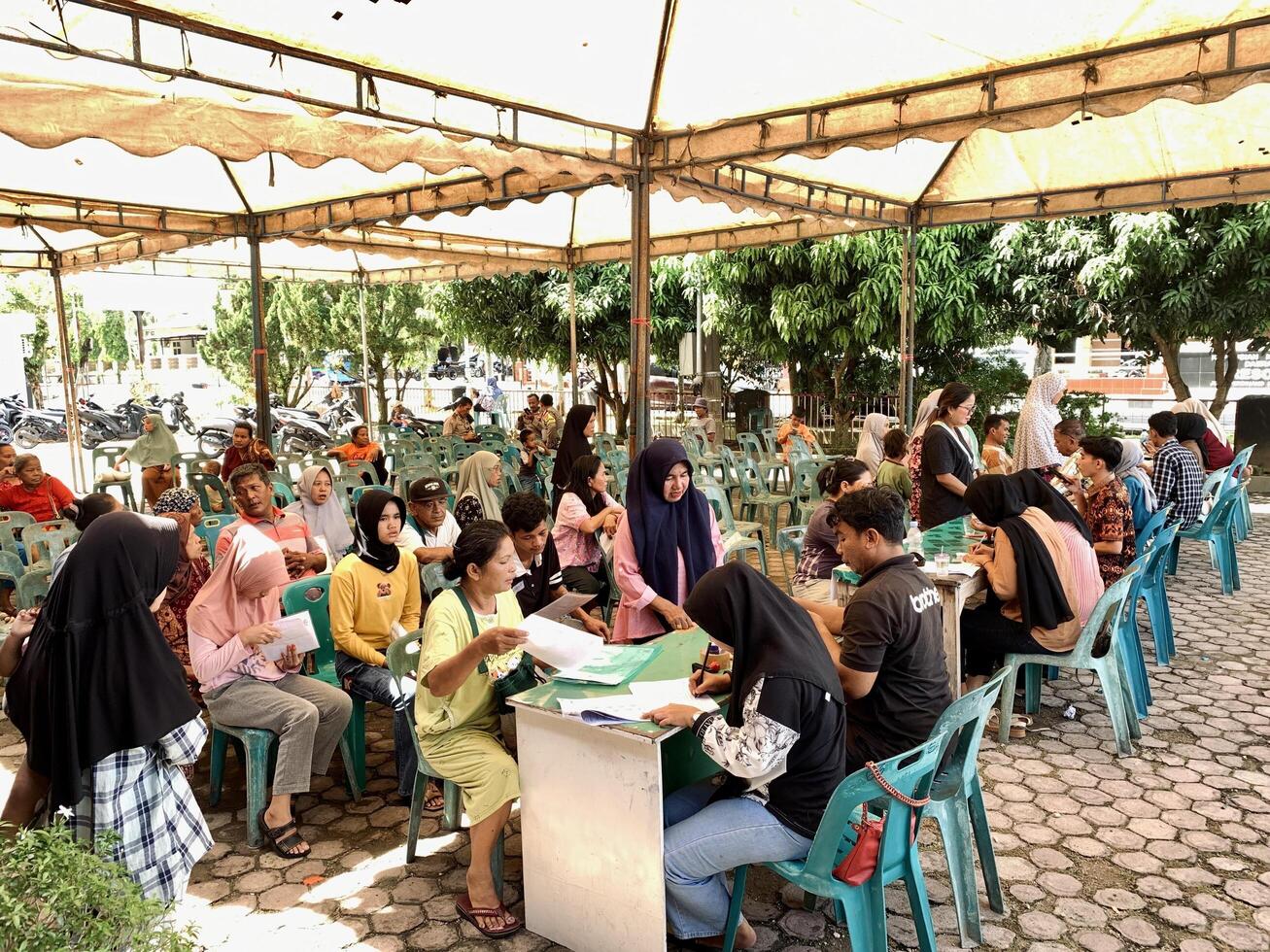 Indonesia - Sibolga, 13 May 2024 a group of Asian mothers are sitting on a bench collecting government rice social assistance photo