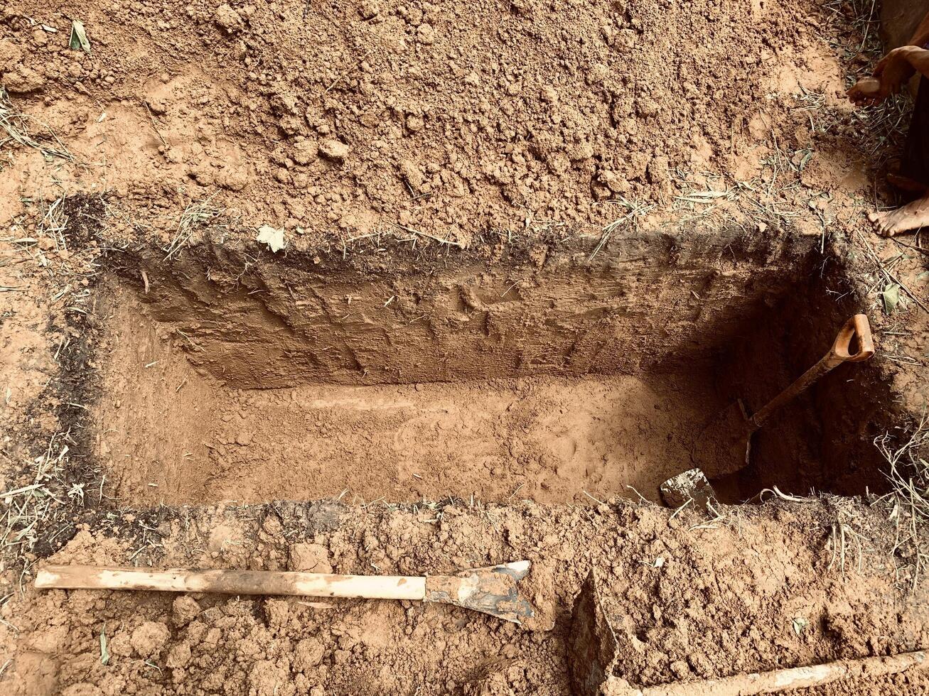 grave with shovel and shovel in the ground photo