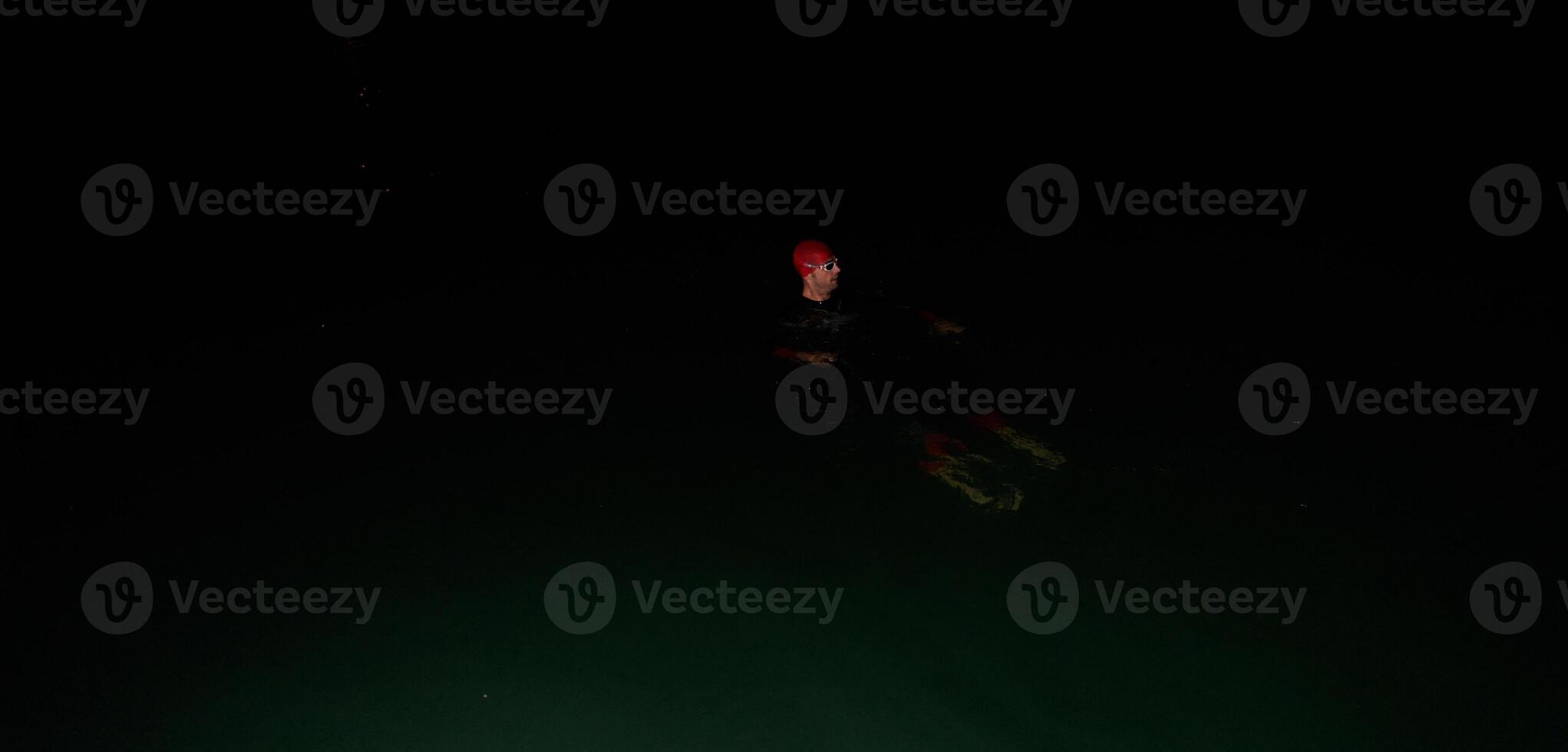 Authentic triathlete swimmer having a break during hard training on night photo