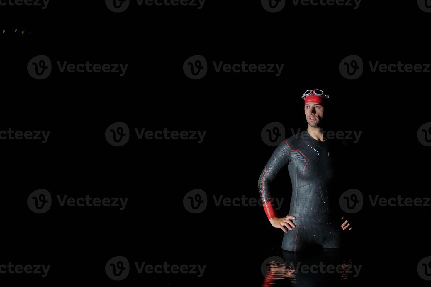 Authentic triathlete swimmer having a break during hard training on night photo