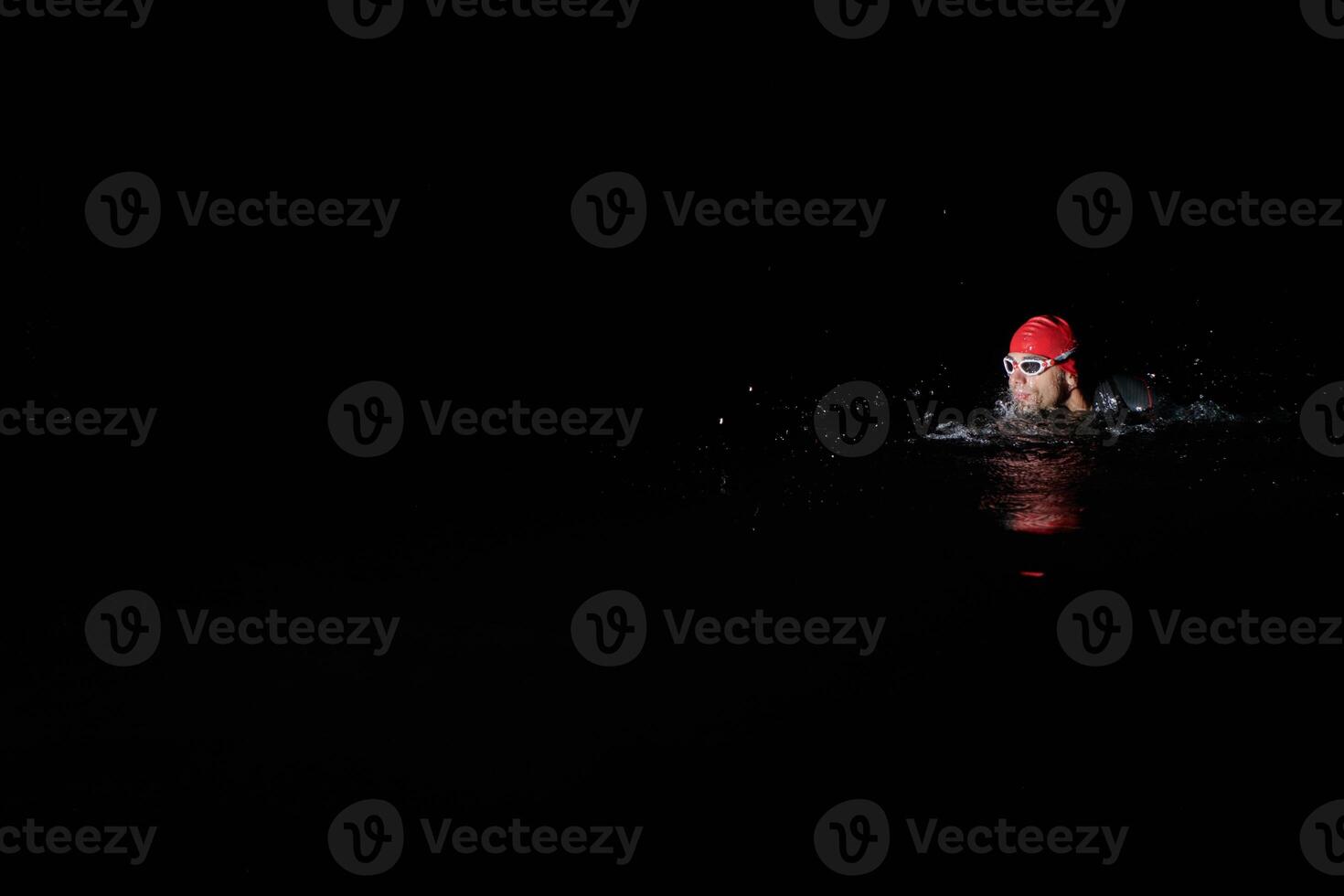 Authentic triathlete swimmer having a break during hard training on night photo