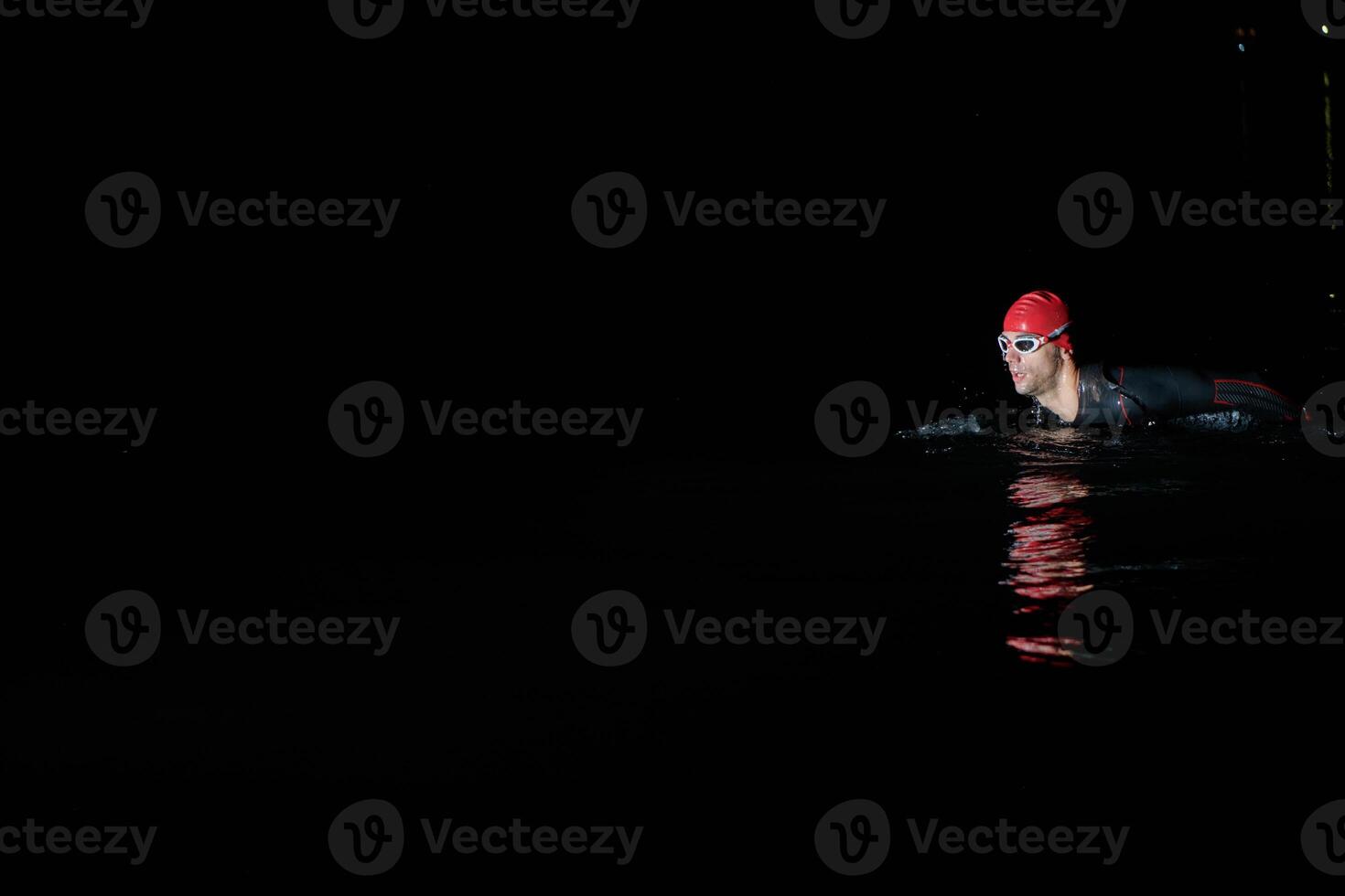 Authentic triathlete swimmer having a break during hard training on night photo