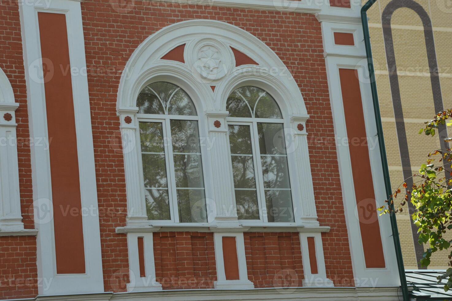 White arched windows against red brick walls. Building facade element. Beautiful architecture. photo