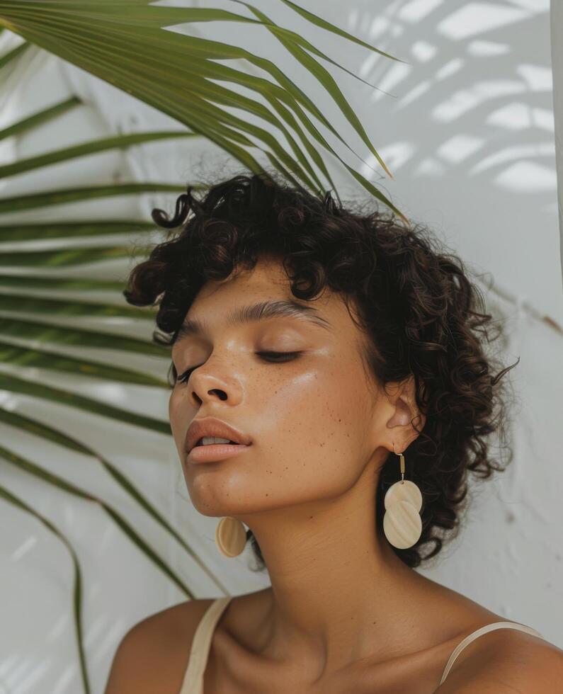Woman Standing Under Palm Tree With Large Earrings photo
