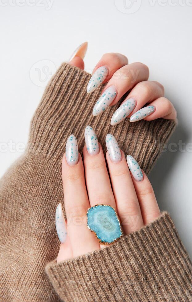 Hands with blue nail polish on cozy sweater photo