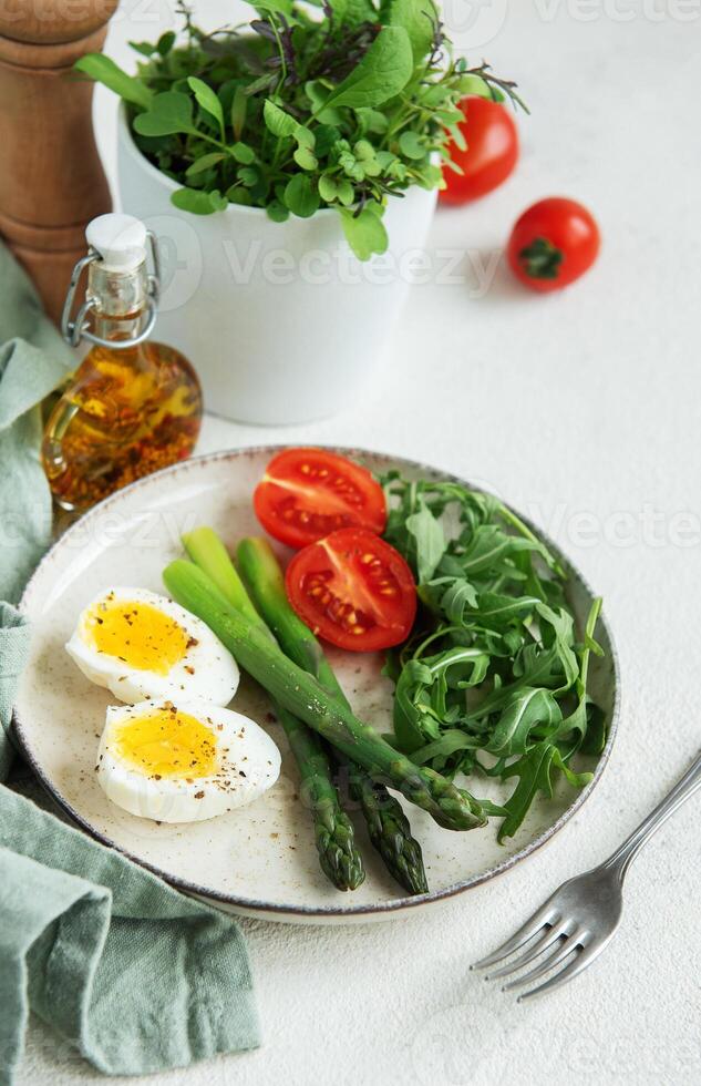 Fresh Spring Salad With Boiled Eggs, Asparagus, and Tomatoes on a Bright Day photo