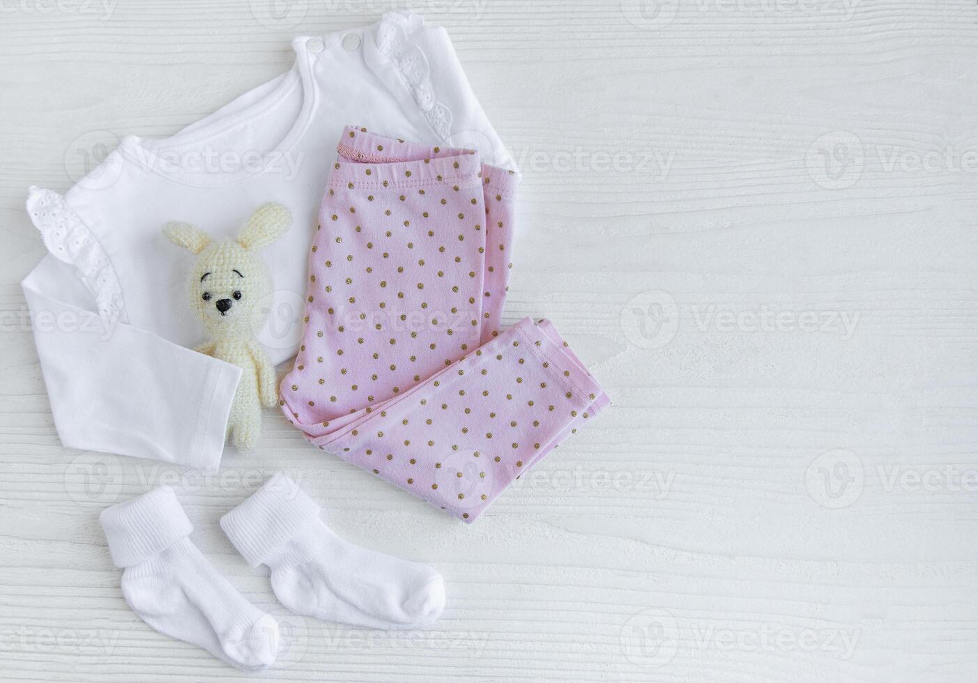 Set of baby bodysuits, pants, socks and knitted toy photo