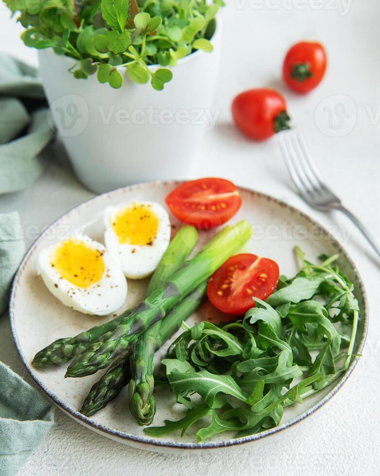 Fresh Spring Salad With Boiled Eggs, Asparagus, and Tomatoes on a Bright Day photo