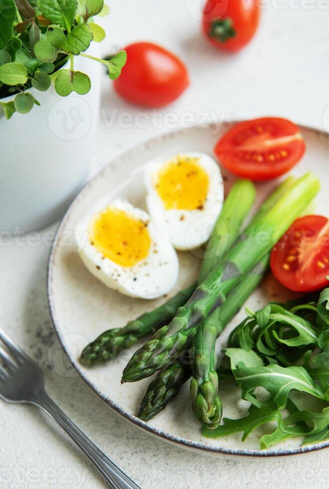 Fresh Spring Salad With Boiled Eggs, Asparagus, and Tomatoes on a Bright Day photo