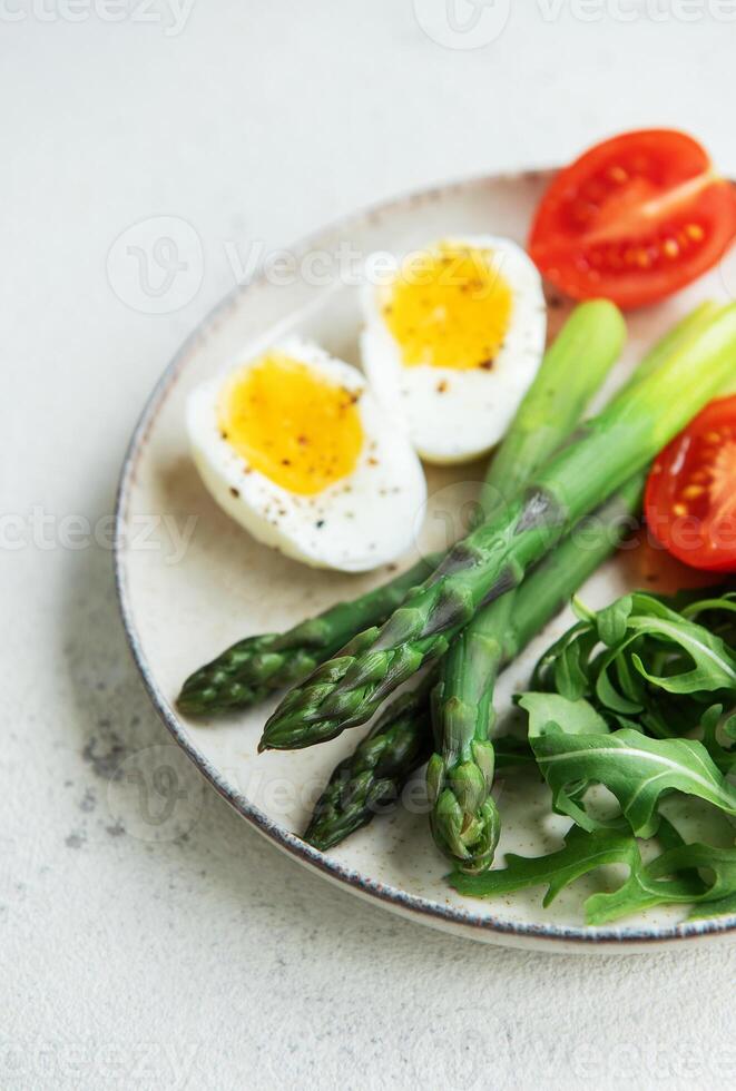Fresh Spring Salad With Boiled Eggs, Asparagus, and Tomatoes on a Bright Day photo