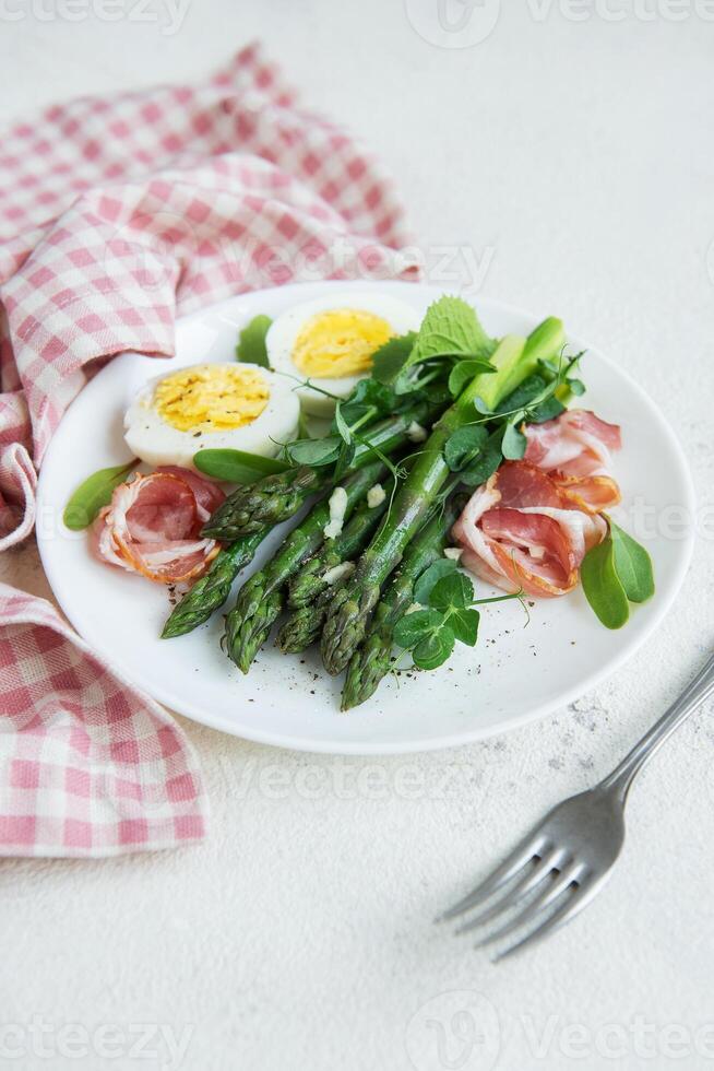 Fresh Asparagus and Prosciutto Salad Served With Boiled Eggs and Microgreens photo