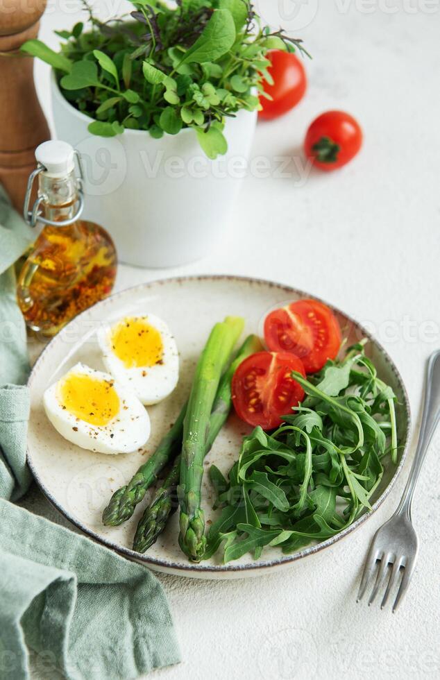 Fresh Spring Salad With Boiled Eggs, Asparagus, and Tomatoes on a Bright Day photo