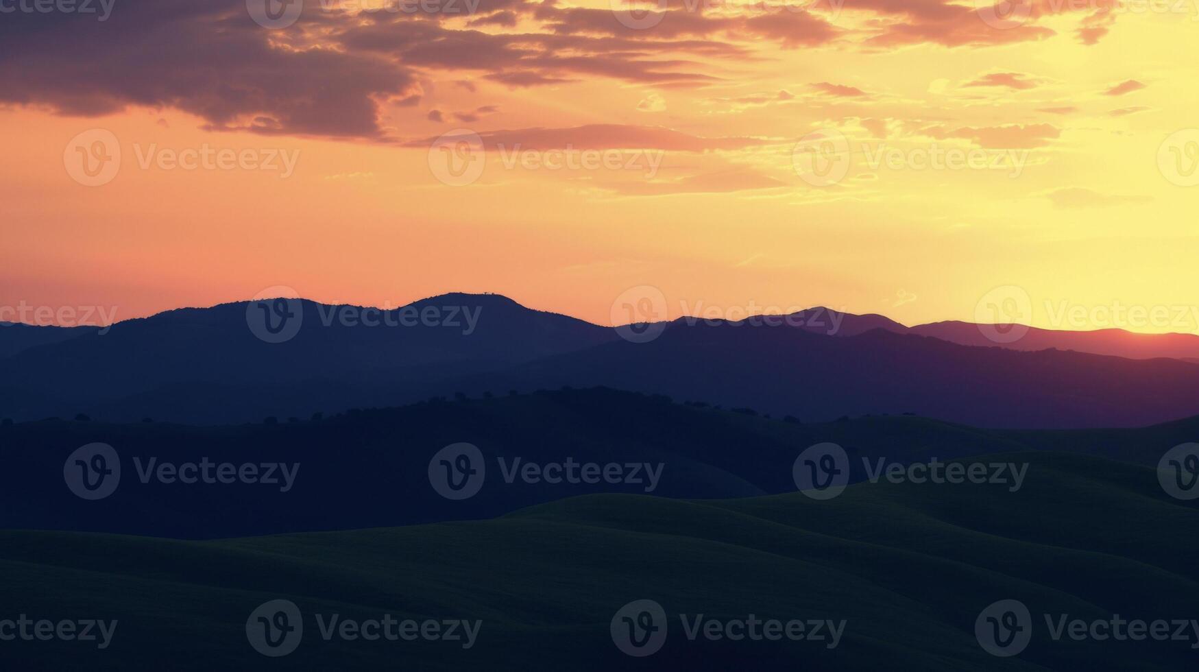 The shadows of rolling hills are cast against the vivid colors of the sky creating a breathtaking countryside silhouette at dusk photo