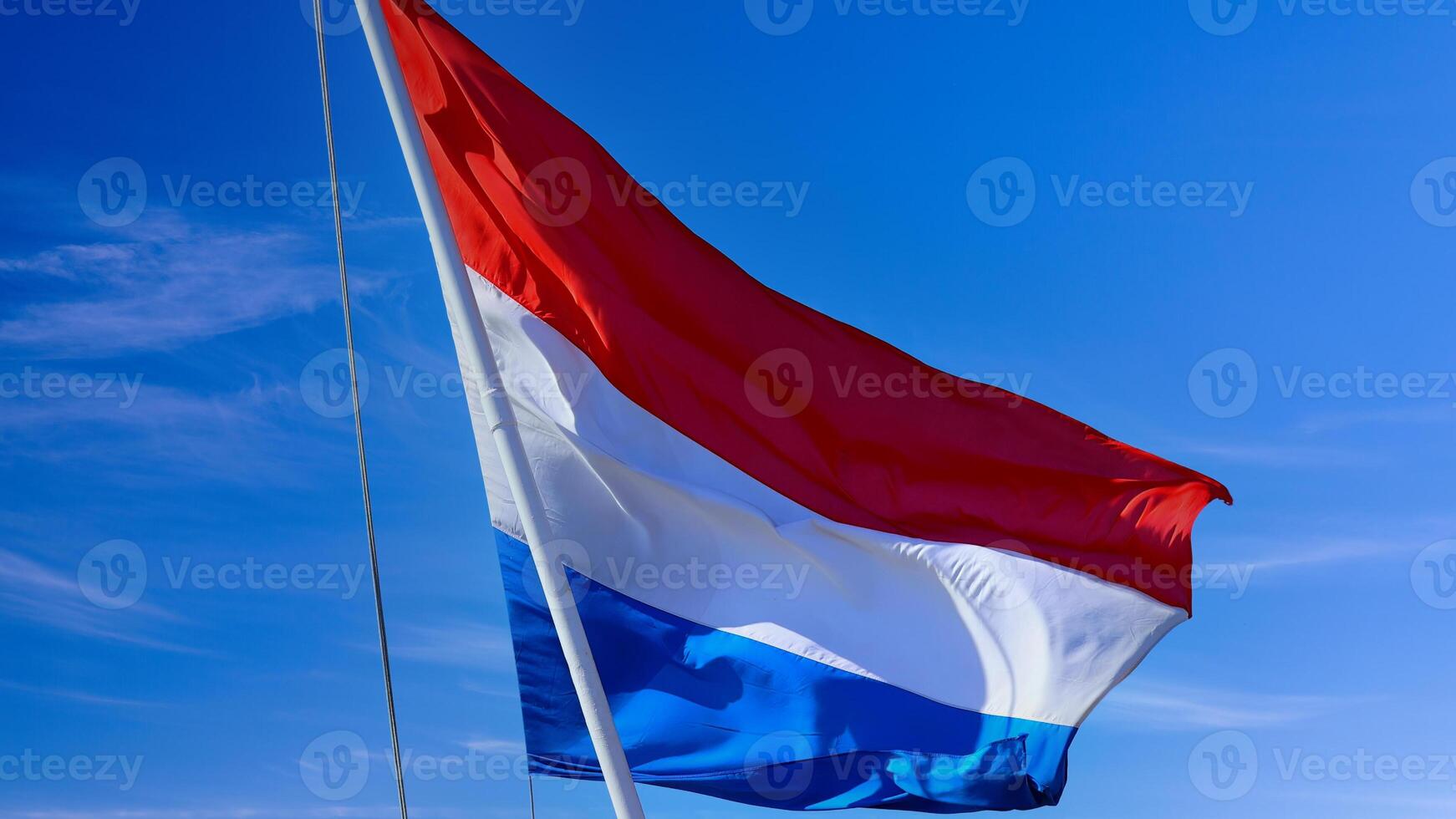 Holland Netherlands Flag proudly waving in the air with blue sky in the background photo