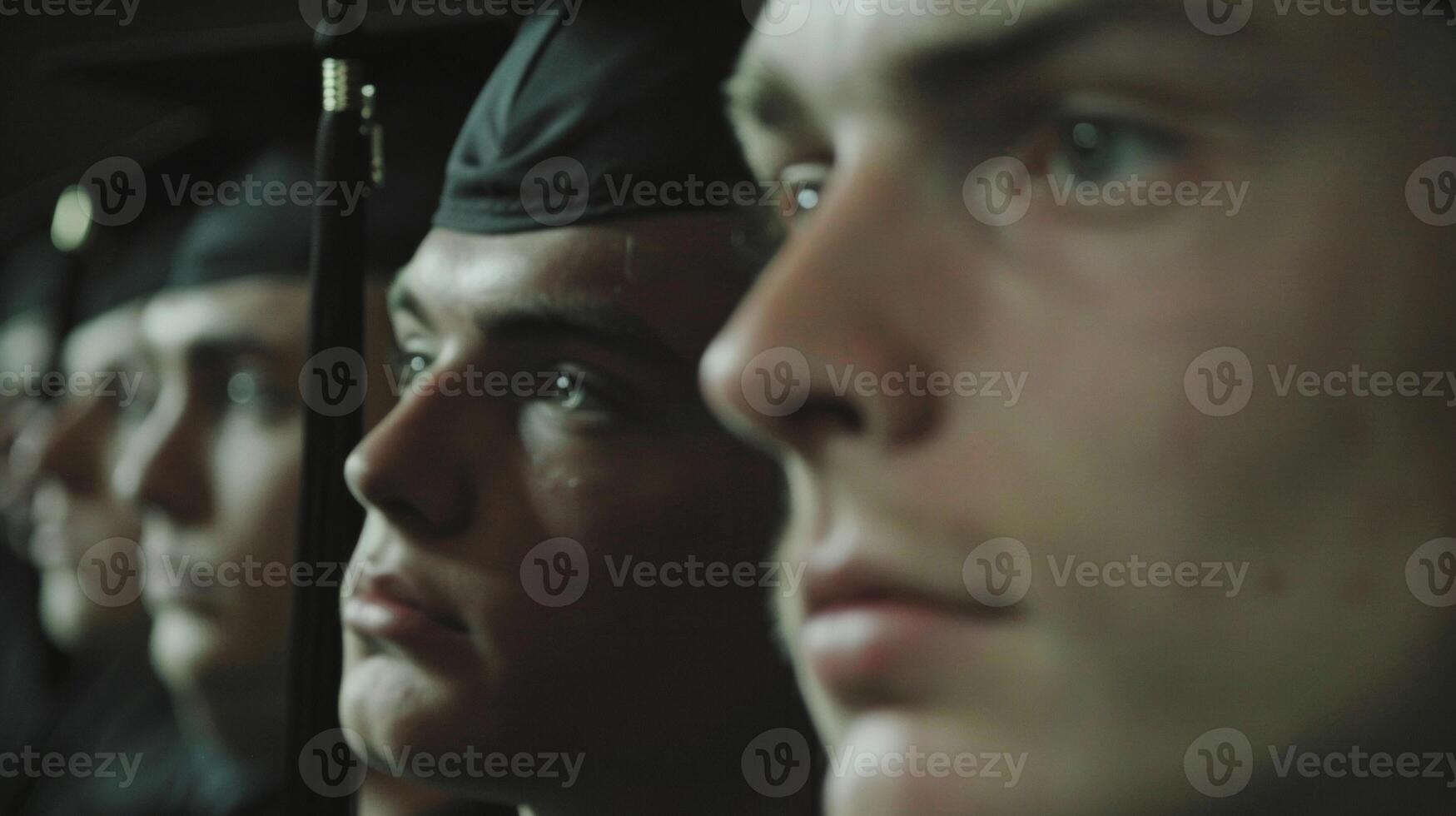 The camera zooms in on a graduates face as they listen intently to a motivational speech. The emotion and determination in their expression reflects the impact of the speaker photo