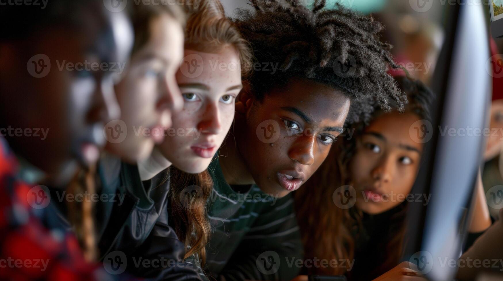 A diverse group of students huddled around a computer screen working together on a project. Each person has a different skill or perspective to contribute highlighting th photo