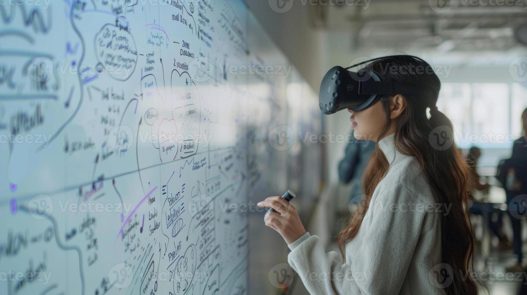 A shot of a student in a VR lab standing in front of a virtual whiteboard and using digital markers to write out equations and diagrams. This showcases the potential for collaboratio photo