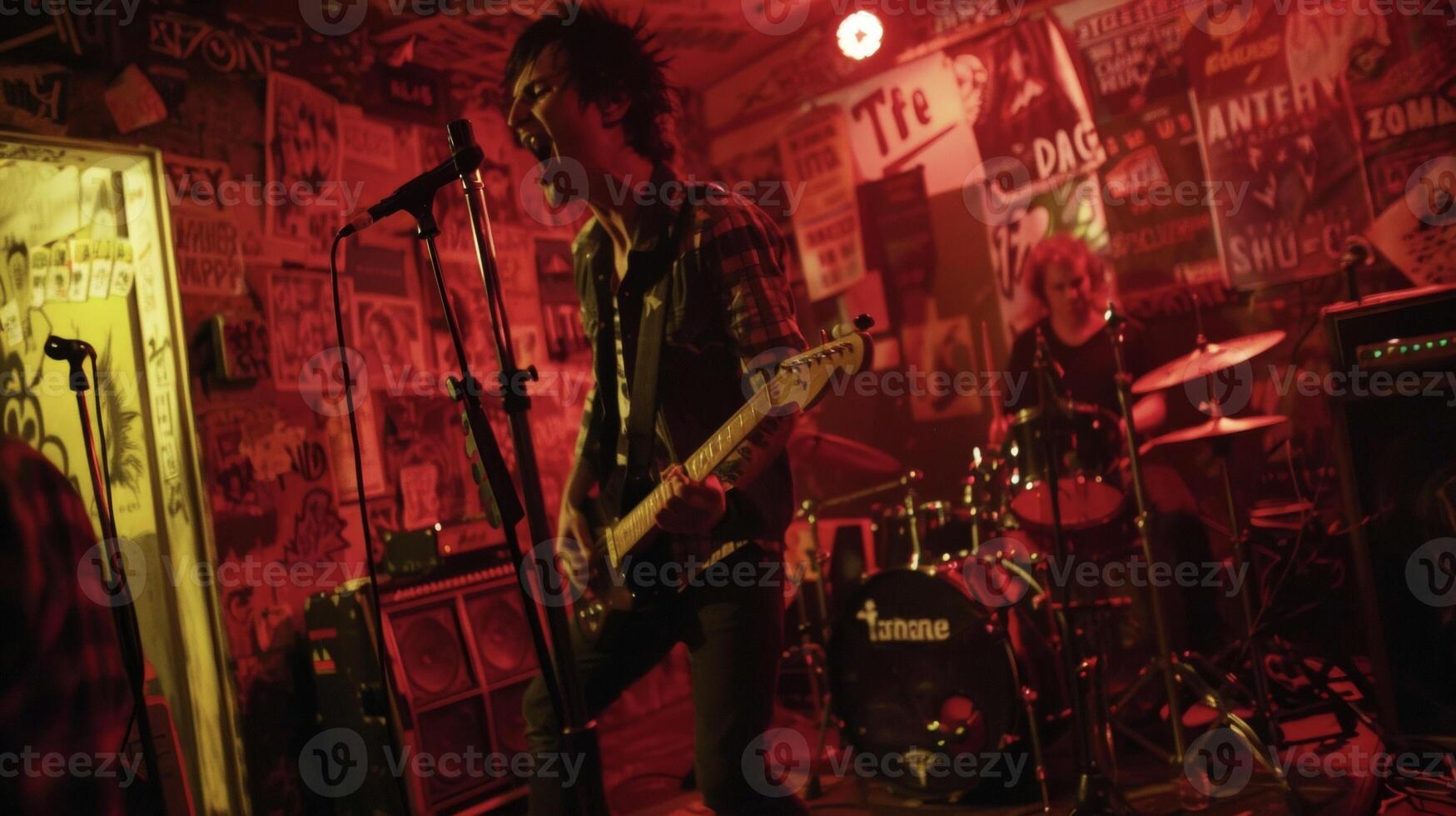 In a grungy underground club a punk band performs on a makeshift stage their electrifying music and frenetic movements commanding the attention of the audience. The wall photo