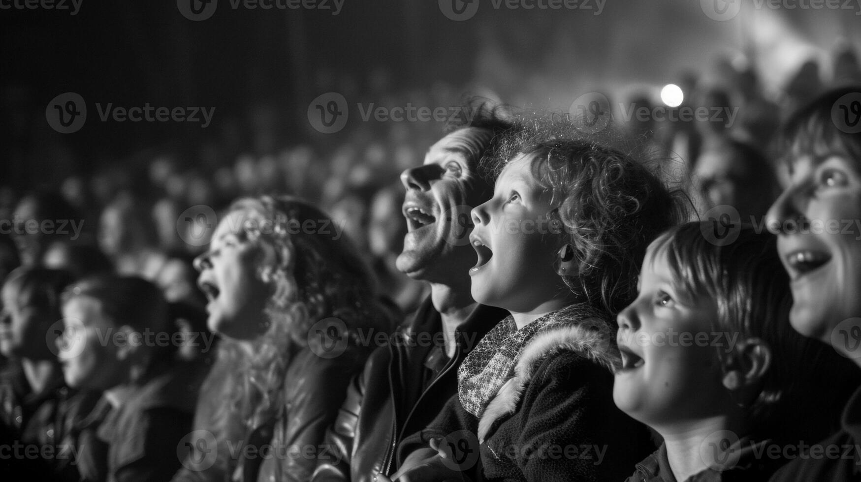 The crowd is fully engrossed in the show with wideeyed children sitting on their parents shoulders and older folks tapping their feet to the lively music. The atmosphere i photo