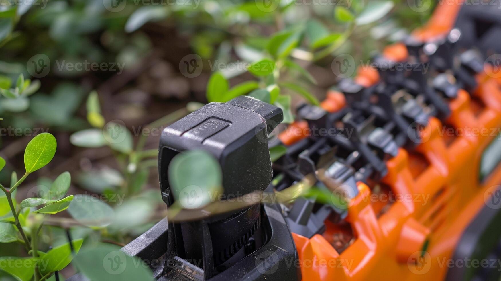 A closeup of the safety guard on an electric hedge trimmer protecting fingers from the sharp blades photo