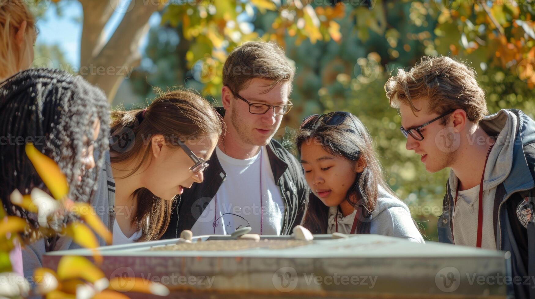 A focused image of the current students and teachers gathered around the time capsule capturing their excitement and curiosity about the institutions history and its connectio photo