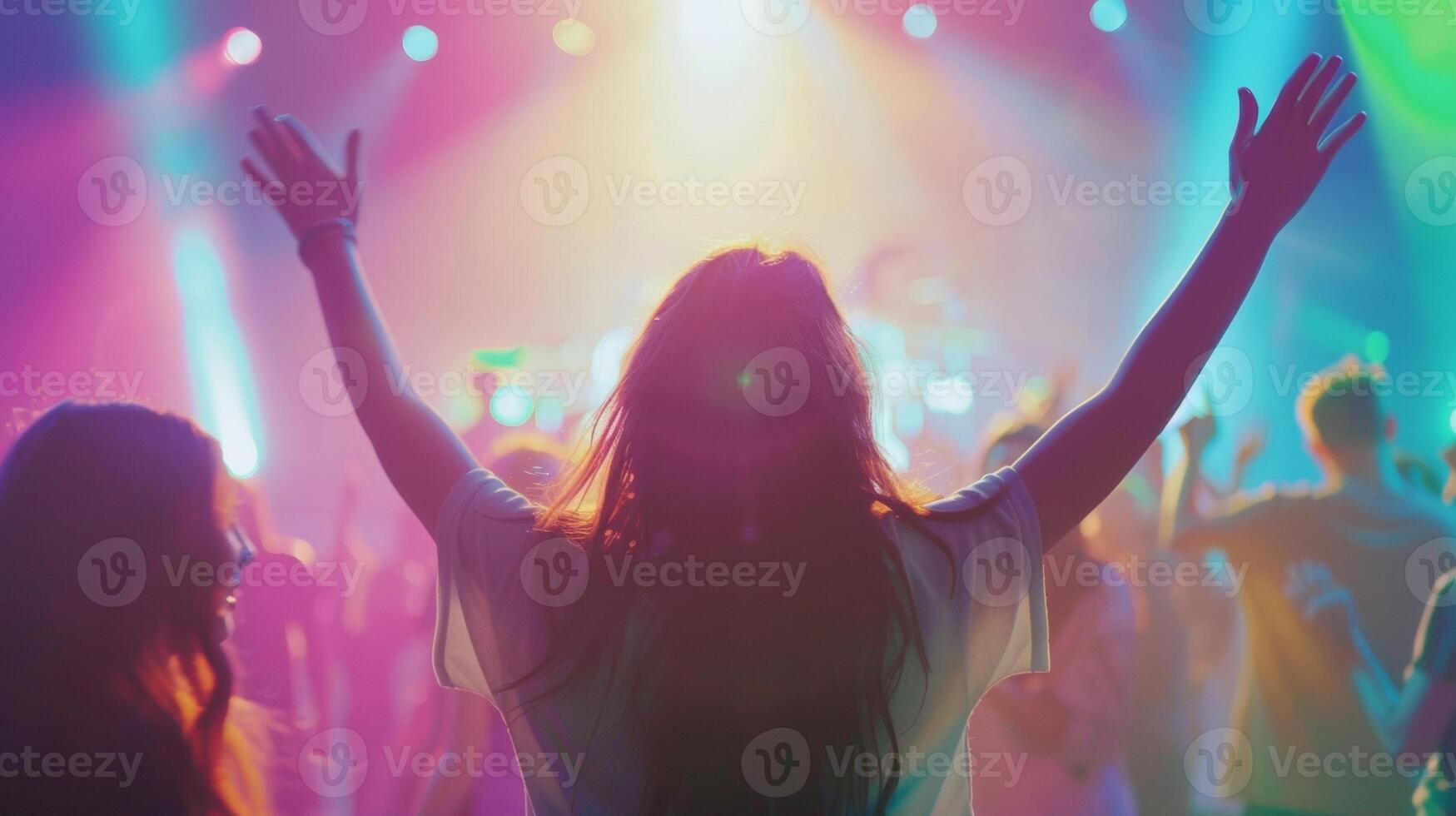 Across the room people facing away from the camera are seen singing and clapping along with the music bodies fully immersed . photo